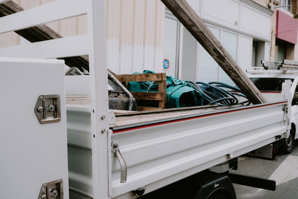 Open flatbed truck loaded with a pallet and coiled materials on a street